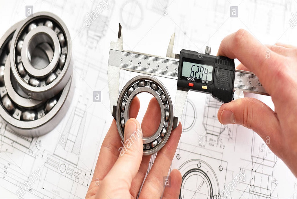 quality-control-in-modern-mechanical-engineering-caliper-gauges-technical-drawing-and-ball-bearings-on-white-background-PXWHNG